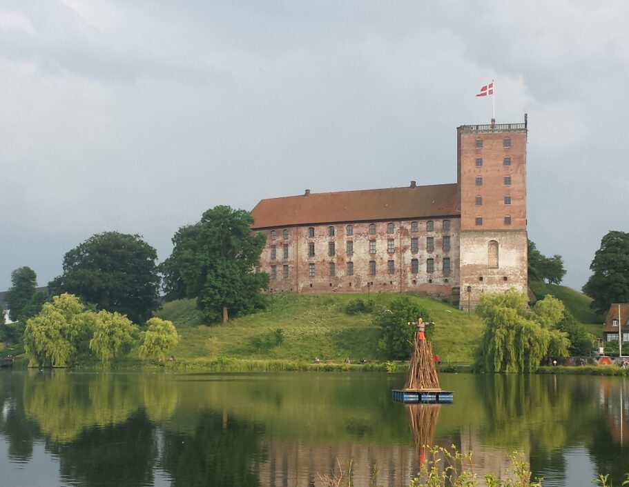 Sankt Hans bål over Kolding fjord med Koldinghus i baggrunden.