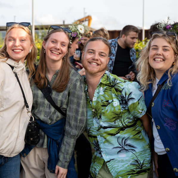 En gruppe unge mennesker står sammen og smiler mod kameraet.