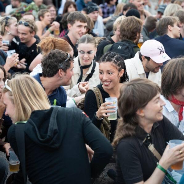 Publikummet står samlet og kigger op mod scenen.