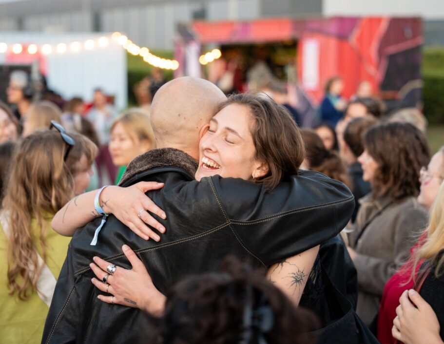 En ung kvinder krammer smilende en mand.