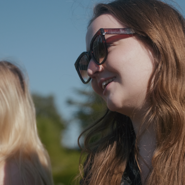 Mette kigger smilende mod noget udenfor framen.