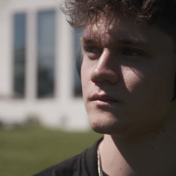 Tobias står udenfor i solskinsvejret med kunstmuseum Trapholt i baggrunden.