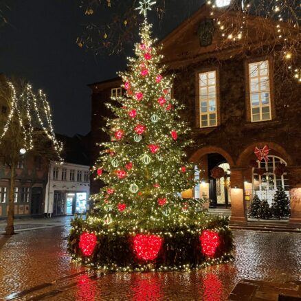 Foran Koldings rådhus står et stort og flot juletræ pyntet med lyskæder, julekugler og lysende hjerter.