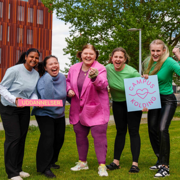 fem glade piger holder et skilt, hvor der står uddannelse og campus kolding